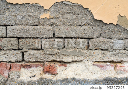 gray brick wall and pieces of plaster closeup background urban 95227293