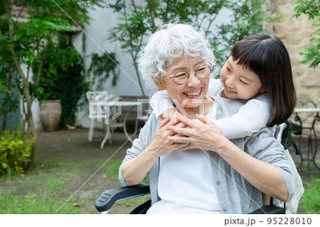 車椅子のシニア女性と孫の女の子 95228010