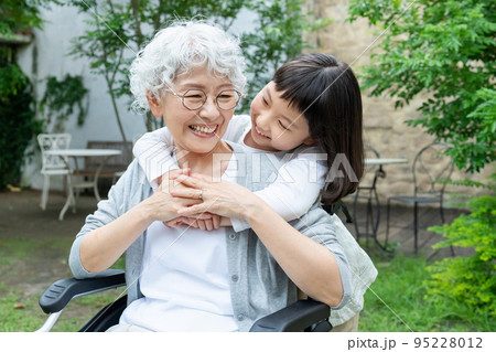 車椅子のシニア女性と孫の女の子 95228012