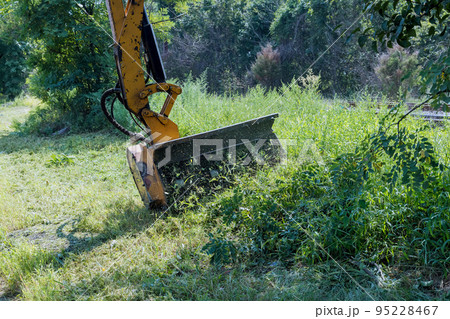 Tractor external equipment mechanization machine mower grass driving on roadside suburban highway road maintenance service 95228467