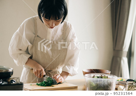 キッチンでネギを切る女性 キッチンでネギを切る女性 95231564