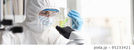 Scientist in protective suit studies toxic poisonous liquids in laboratory 95233421