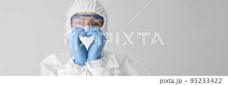 Doctor in protective suit makes heart gesture with hands 95233422