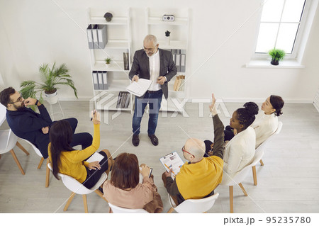 Team of employees having a meeting, discussing something, and asking their manager questions 95235780