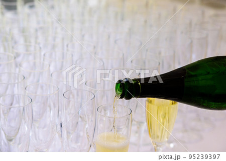 pooring champagne into a champagne flute 95239397