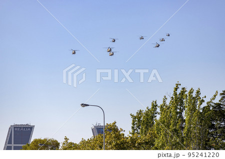 Helicopter. Airplane. Military vehicle. Spanish Air Force on the day of the National Holiday of October 12 flying over the streets of the city of Madrid. MADRID, SPAIN - OCTOBER 12, 2022. 95241220