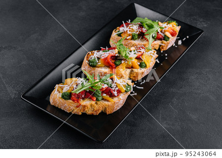 bruschetta with roasted peppers, pesto and parmesan cheese 95243064