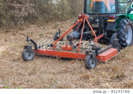 It is common in autumn to use tractor to trim or remove small branches that grow on ground during season It is common in autumn to use tractor to trim or remove small branches that grow on ground during season 95243766