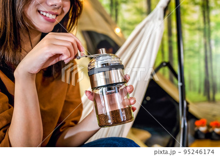 グランピング　キャンプ場で朝のコーヒーを準備する若い女性 95246174