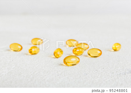 Heap of yellov pills on colored background. Tablets scattered on a table. Pile of red soft gelatin capsule. Vitamins and dietary supplements concept Heap of yellov pills on colored background. Tablets scattered on a table. Pile of red soft gelatin capsule. Vitamins and dietary supplements concept 95248801