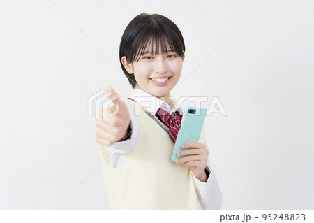 スマホを持ってグッドサインする高校生　白背景 95248823