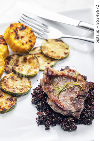 grilled pork steak with zucchini and corn served with black quinoa 95249672
