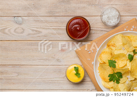 Top view chips with sause in bowl on colored background, top view with copy space Top view chips with sause in bowl on colored background, top view with copy space 95249724