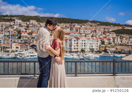 Couple in love tourists enjoying the views of Architecture and luxury yachts in Lustica Bay, Montenegro. Travel around Montenegro concept. Go Everywhere Couple in love tourists enjoying the views of Architecture and luxury yachts in Lustica Bay, Montenegro. Travel around Montenegro concept. Go Everywhere 95250126