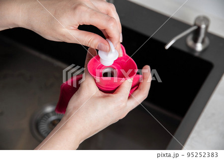 A woman twists a cork in a medical heating pad. Heat treatment, close-up A woman twists a cork in a medical heating pad. Heat treatment, close-up 95252383