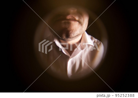 View from the peephole. A man in a white shirt is standing near the front door. The concept of breaking the law. Debt collection, collector. 95252388