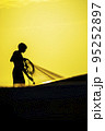 Silhouette of a fisherman at sunset 95252897