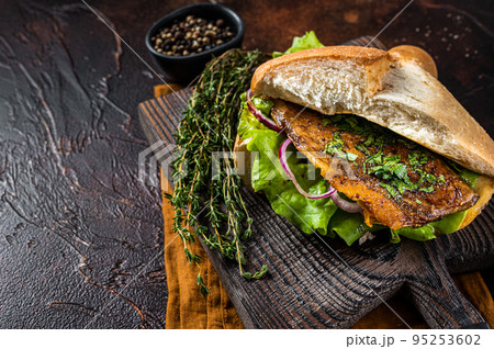 Turkish Street Food Balik Ekmek, fish sandwich with grilled mackerel fillet in a bun. Dark background. Top view. Copy space 95253602