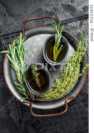 Assorted fresh herbs with olive oil. Top view. Dark background 95253643
