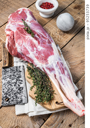 Butcher board with Raw lamb mutton leg with herbs. Wooden background. Top view Butcher board with Raw lamb mutton leg with herbs. Wooden background. Top view 95253739