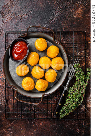 Potato croquettes, mashed potatoes balls breaded and deep fried. Dark background. Top view Potato croquettes, mashed potatoes balls breaded and deep fried. Dark background. Top view 95253741