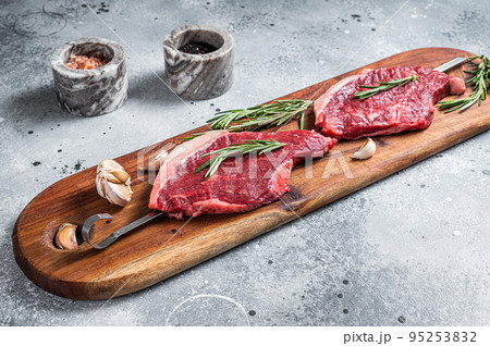Raw Picanha Brazilian Grilling Steaks with herbs and spices. Gray background. Top view Raw Picanha Brazilian Grilling Steaks with herbs and spices. Gray background. Top view 95253832