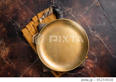 Metal plate on table. Food cooking and healthy eating background. Dark background. Top view. Copy space Metal plate on table. Food cooking and healthy eating background. Dark background. Top view. Copy space 95254038