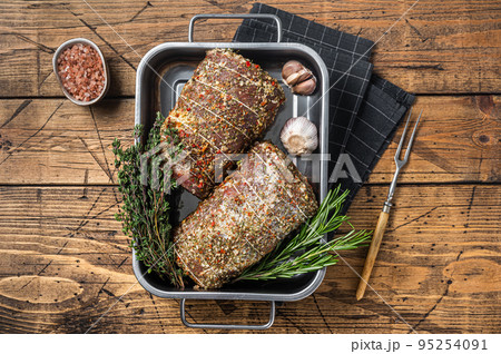 Raw Rolled pork belly italian Porchetta with herbs and spices. Wooden background. Top view Raw Rolled pork belly italian Porchetta with herbs and spices. Wooden background. Top view 95254091