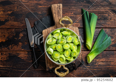 Sliced Green Leek onion in skillet. Wooden background. Top view Sliced Green Leek onion in skillet. Wooden background. Top view 95254602