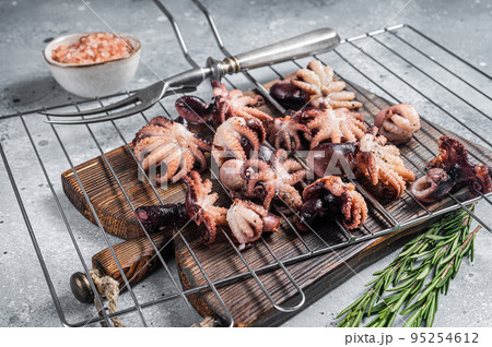 Grilled baby mini octopuses on a grill. Gray background. Top view Grilled baby mini octopuses on a grill. Gray background. Top view 95254612