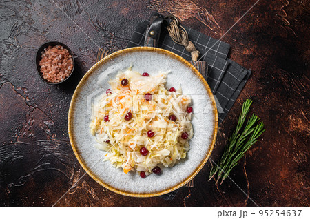 Fresh healthy sauerkraut in bowl with black pepper and cranberry. Dark background. Top view 95254637