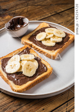Cooking of sandwich with chocolate Hazelnut butter and bananas. Wooden background. Top view 95254720