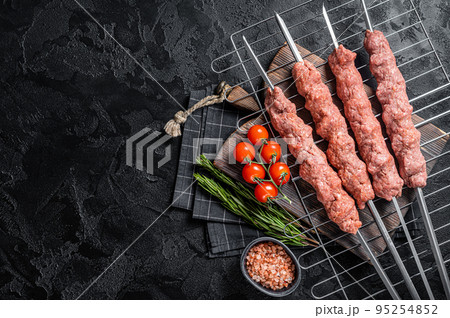 Raw Shish kebab from mince lamb and beef meat, turkish adana kebab on Skewers. Black background. Top view. Copy space 95254852