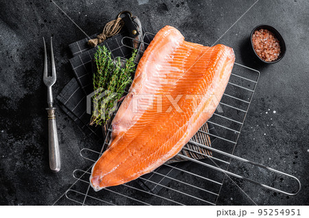 Raw salmon fish fillet, cooking steaks on grill with herbs. Black background. Top view 95254951