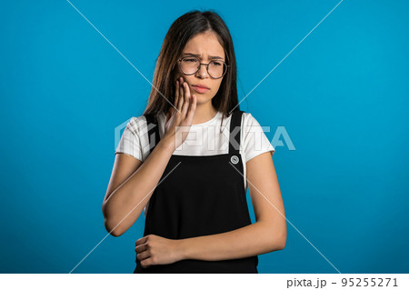 Young pretty asian woman with tooth pain on blue studio background. Toothache, dental problems 95255271