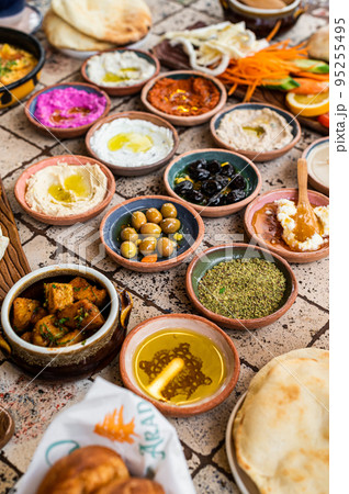 Traditional Turkish Village Breakfast on the ceramic table with pastries, vegetables, greens, spreads, cheeses, fried eggs, jams. Top view Traditional Turkish Village Breakfast on the ceramic table with pastries, vegetables, greens, spreads, cheeses, fried eggs, jams. Top view 95255495