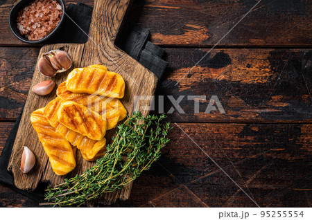 Fried on grill Halloumi cheese with herbs and thyme. Wooden background. Top view. Copy space Fried on grill Halloumi cheese with herbs and thyme. Wooden background. Top view. Copy space 95255554
