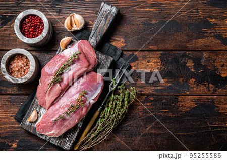 Raw Duck breasts, poultry meat steaks on wooden board ready for cooking. Wooden background. Top view. Copy space 95255586