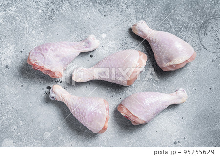 Raw uncooked chicken legs, drumsticks on stone table. Gray background. Top view Raw uncooked chicken legs, drumsticks on stone table. Gray background. Top view 95255629