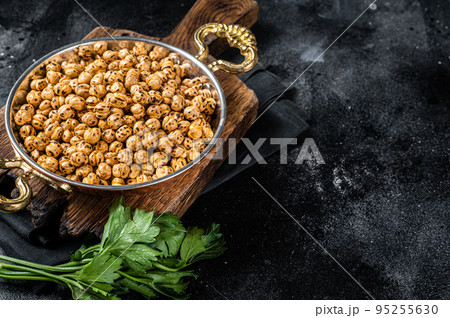 Fried chickpeas with turmeric, roasted spicy chickpeas or Indian chana or chole in a skillet. Black background. Top view. Copy space 95255630