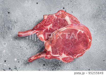 Raw Tomahawk beef (veal) steak on butcher table. Gray background. Top view Raw Tomahawk beef (veal) steak on butcher table. Gray background. Top view 95255649