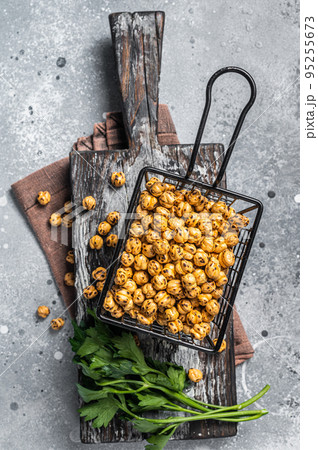 Healthy snack roasted spicy chickpeas in a basket. Gray background. Top view Healthy snack roasted spicy chickpeas in a basket. Gray background. Top view 95255673