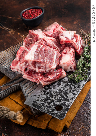 Butcher board with Raw diced beef and lamb meat ready for cooking. Dark background. Top view Butcher board with Raw diced beef and lamb meat ready for cooking. Dark background. Top view 95255767