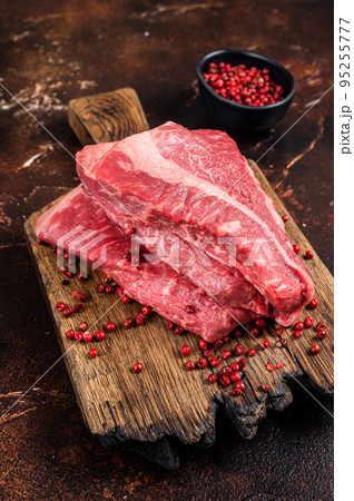 Raw sirloin beef cut, Silverside steak on a wooden board. Dark background. Top view 95255777