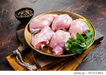 Free range Raw Boneless and skinless Chicken leg thigh fillet with spices. Dark background. Top view 95255805