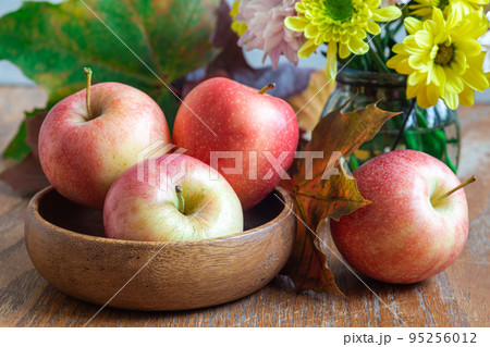 Autumn season or Thanksgiving holiday concept with apples, flowers and fall leaves, horizontal 95256012