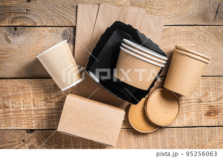 Disposable paper tableware. Eco friendly Recycling set of paper cups, dishes, bag, fast food containers and cutlery. Wooden background. Top view. Copy space 95256063