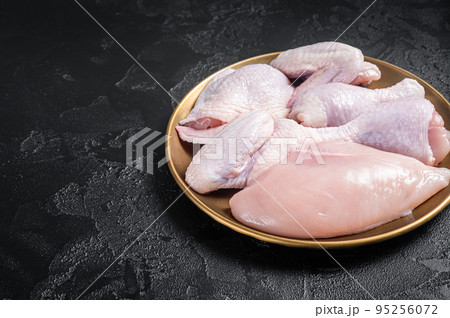 Fresh raw chicken meat with various parts - drumstick, breast fillet, wings, thigh. Black background. Top view. Copy space Fresh raw chicken meat with various parts - drumstick, breast fillet, wings, thigh. Black background. Top view. Copy space 95256072