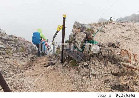 雨の中八方尾根方面へ向かう登山者 95256362