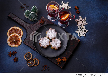 Hot mulled wine with a slice of orange, with cinnamon, cloves and other spices Hot mulled wine with a slice of orange, with cinnamon, cloves and other spices 95256722